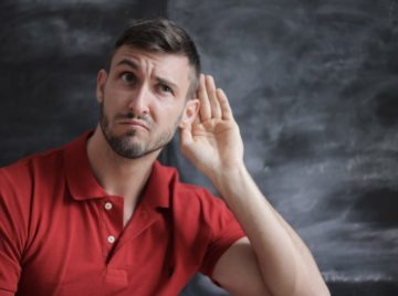 Man signals a listening gesture on the subject of Perfect Pitch
