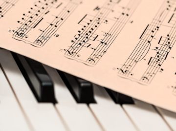 Picture of a piano & sheet music to go with the songwriting