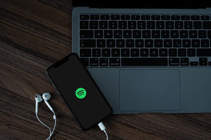Handy mit Kopfhörern und Spotify-Logo zum Thema Spotify Betrug