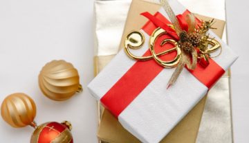 Ein Weihnachtsgeschenk für Musiker mit roter Schleife und einem goldenen Notenschlüssel