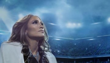 Jennifer Lopez steht in einem großen Stadion und schaut nach oben