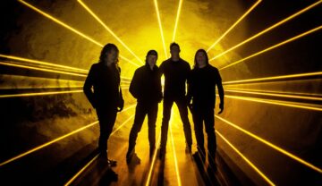 Die Band Metallica steht vor einem Strahlenmeer aus Scheinwerfern in gelb