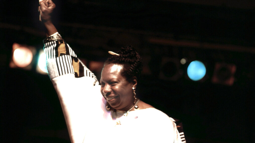 Nina Simone auf der Bühne, ihre Hand in die Höhe gestreckt
