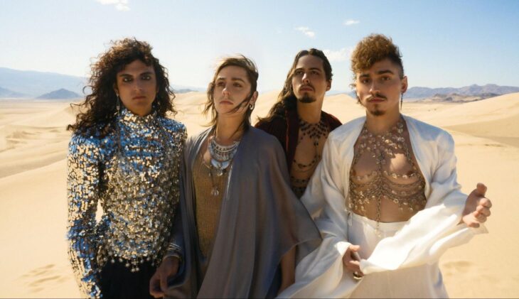 Die Band Greta Van Fleet steht in schillernden Klamotten in einer Wüste